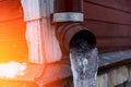 frozen water in downspout gutter of the roof drainage system with ice