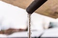 Frozen water flowing from the roof through a plastic pipe with a string inside. Royalty Free Stock Photo