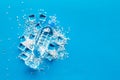 Frozen water in ice cubes and plastic bottle on blue bar table top view mockup Royalty Free Stock Photo