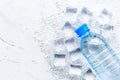 Frozen water in ice cubes and plastic bottle on marble bar table top view mockup Royalty Free Stock Photo