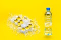 Frozen water in ice cubes and plastic bottle on yellow bar table top view mockup Royalty Free Stock Photo