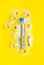 Frozen water in ice cubes and plastic bottle on yellow bar table top view mockup Royalty Free Stock Photo