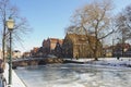 Hoorn, North Holland / Netherlands - March 11, 2012: Frozen water and show on canal and traditional old brick buildings with tile