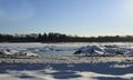 Frozen water and snow piles  blue sky tire marks in front Royalty Free Stock Photo