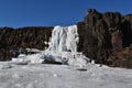 Frozen waterfall in clear blue sky in Thingvellir National Park, Iceland Royalty Free Stock Photo