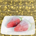 Frozen watermelon slices on a plate. Wooden background, heart shaped bokeh Royalty Free Stock Photo