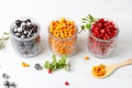 Frozen wild berries in glass jars. Close-up on a white background, horizontal frame Royalty Free Stock Photo