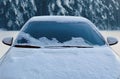 Frozen winter car covered snow, view front window windshield and hood on snowy forest Royalty Free Stock Photo