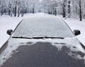 Frozen winter car covered snow, view front window windshield and hood on snowy forest Royalty Free Stock Photo