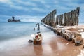 Frozen wooden breakwaters line to the world war II torpedo platform at Baltic Sea Royalty Free Stock Photo