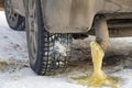 Frozen yellow water condensate with gasoline from the exhaust pipe of a car