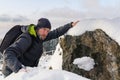 Frozen young man in jacket and backpack climbing on snow rock, stone. Novohradske mountain, Czech republic Royalty Free Stock Photo