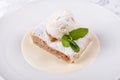 Fruit apple strudel cake served with ice cream, mint leaf and vanilla sauce. Classical austrian dessert on white plate Royalty Free Stock Photo