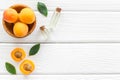 Fruit aroma oil. Apricot kernel oil on white wooden background top view frame copy space Royalty Free Stock Photo