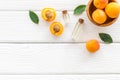 Fruit aroma oil. Apricot kernel oil on white wooden background top view frame space for text Royalty Free Stock Photo