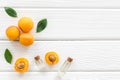 Fruit aroma oil. Apricot kernel oil on white wooden background top view frame copy space Royalty Free Stock Photo