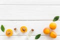 Fruit aroma oil. Apricot kernel oil on white wooden background top view frame copy space Royalty Free Stock Photo