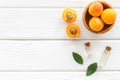 Fruit aroma oil. Apricot kernel oil on white wooden background top view frame space for text Royalty Free Stock Photo