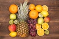 Fruit background with orange, kiwi, grape, apples and lemon on the wooden table