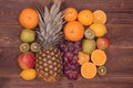 Fruit background with orange, kiwi, grape, apples and lemon on the wooden table