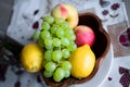 A fruit basket with apples of different qualities, peach and grapes on a white background Royalty Free Stock Photo