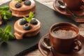 Fruit basket on a serving board and a cup of coffee on the table, fruit muffin with berries