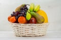 Fruit basket on white background with apple, pear melon grapes orange banana