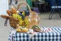 Fruit basket and wine. On a picnic. Grapes and wine in a basket on a stall. Beside the basket lies bread and cheese. The concept Royalty Free Stock Photo