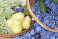 Fruit baskets. Fresh plums, grapes and pears in wooden baskets