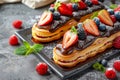 Fruit and Berry Eclair Cakes, Delicious Fruits Milk Dessert, Chocolate Mirror Glazed Eclairs Royalty Free Stock Photo