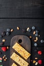 Fruit berry and nut energy bars. Healthy snack, top view with copy space, on black wooden table Royalty Free Stock Photo