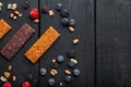 Fruit berry and nut energy bars, healthy snack, top view with copy space, on black wooden table Royalty Free Stock Photo