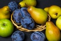Fruit on a black background. Plums, pears and apples lie side by side. Royalty Free Stock Photo