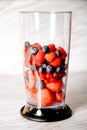 Fruit in a blender, mixer. Fruit cocktail and healthy food and drinks. Strawberry, raspberry, blueberry. Diet and vitamins for Royalty Free Stock Photo