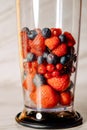 Fruit in a blender, mixer. Fruit cocktail and healthy food and drinks. Strawberry, raspberry, blueberry. Diet and vitamins for Royalty Free Stock Photo