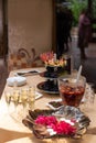 fruit bowl with fig slices, white and black grapes, a glass with lollipops, a plate with sliced smoked meats