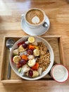 Fruit bowl with granola and yoghurt on wooden tray and coffee cup Royalty Free Stock Photo