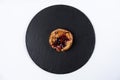 Fruit bun with honey on round black rock stand on white background. Puff with fruit and honey in cafe. View from above