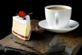 Fruit cake with cherries, grapes and plum stands on a wild stone next to a white cup of coffee with a foam Royalty Free Stock Photo