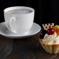 Fruit cake with cherries, grapes and plum stands on a wild stone next to a white cup of coffee with a foam Royalty Free Stock Photo