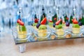 Fruit canapes on a glass tray, on the background of wine glasses and champagne. Catering concept