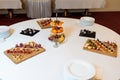 Fruit canapes and sweets lie on a white table