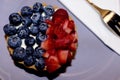 Fruit cheesecake with fork and napkin on a purple plate - blueberry and strawberry cream cake Royalty Free Stock Photo