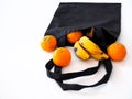 Fruit in a cloth bag with oranges and bananas isolated on white background