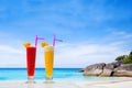 Fruit cocktails on paradise beach, couple of glasses of smoothies