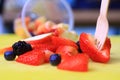 Fruit cup with a fork and spilled fruits