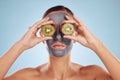 Fruit, eyes and woman with kiwi and face mask for skincare or organic treatment isolated in blue studio background