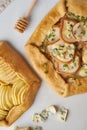 Fruit galette, apple pie with honey, savory pear and cheese pie, marble table, vertical, top view Royalty Free Stock Photo