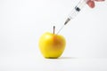 Fruit genetic modification concept. A syringe injects a chemical into an apple on a white background Royalty Free Stock Photo