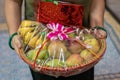fruit gift wrap filled with different fruits and gift pack holding at hand from flat angle